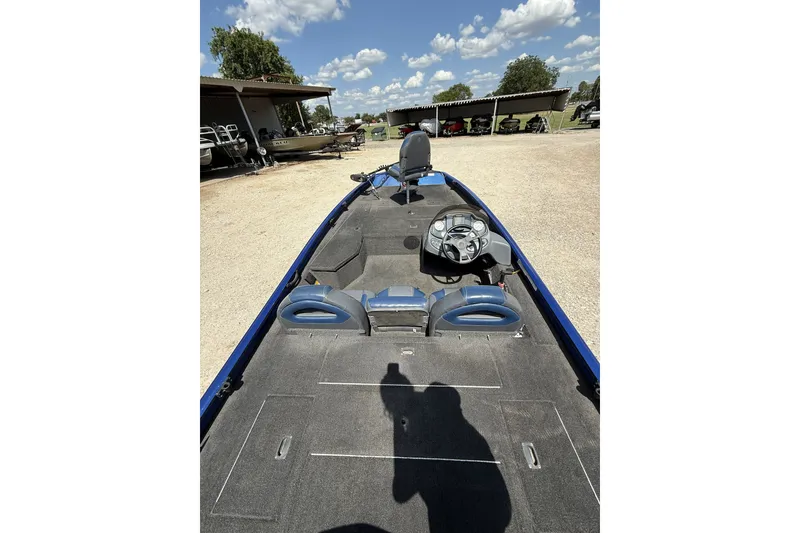 Slide: The Image of 2014 Lowe Stinger 175 boat interior with steering wheel and seating, parked outdoors. - 6
