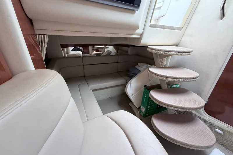 Slide: The Image of Interior of 2006 Sea Ray Sundancer 320, featuring beige seating and spiral staircase. - 25