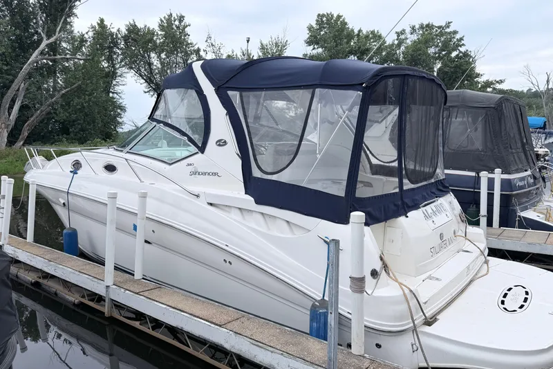 The Image of 2006 Sea Ray Sundancer 320 docked, featuring a sleek design and blue canopy. - 0