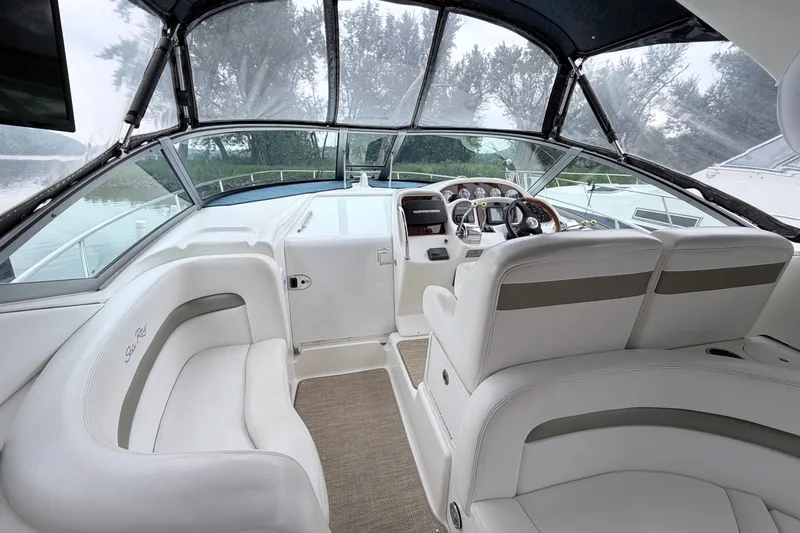 Slide: The Image of Interior of 2006 Sea Ray Sundancer 320 boat, featuring sleek white seating and modern controls. - 8