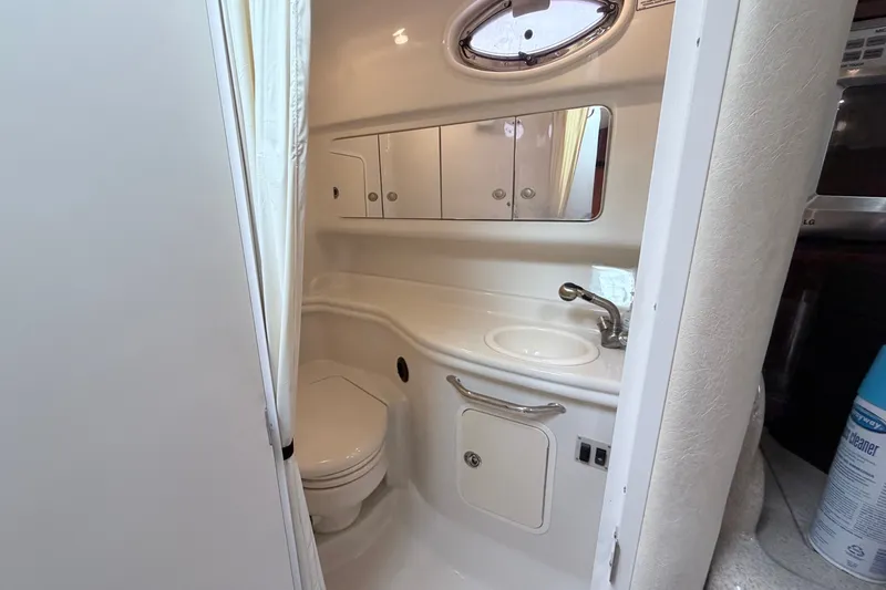 Slide: The Image of Compact bathroom in 2006 Sea Ray Sundancer 320 yacht, featuring sink, toilet, and storage cabinets. - 29