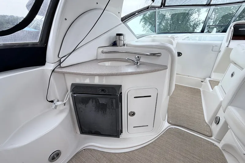 Slide: The Image of 2006 Sea Ray Sundancer 320 interior with sink, mini fridge, and seating area. - 7