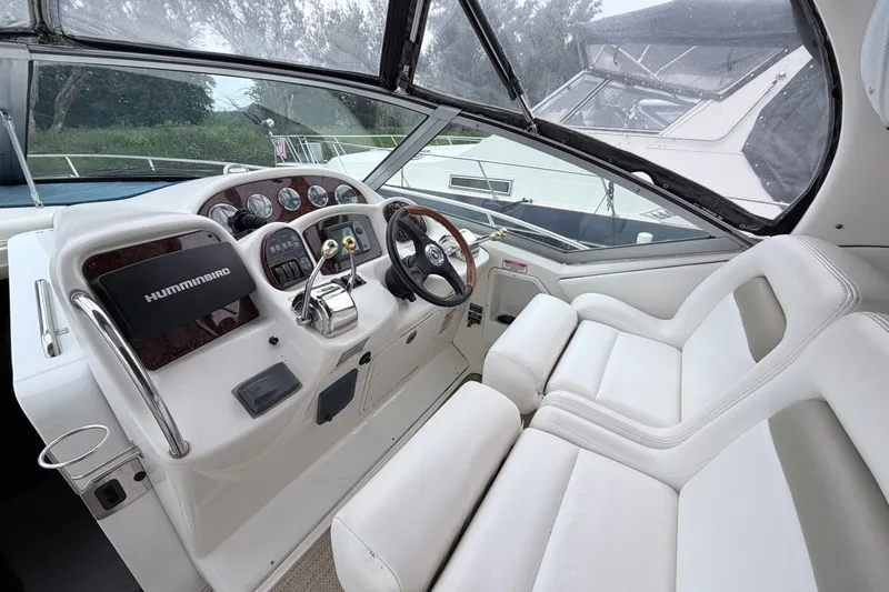 Slide: The Image of 2006 Sea Ray Sundancer 320 cockpit with steering wheel, controls, and white seating. - 10