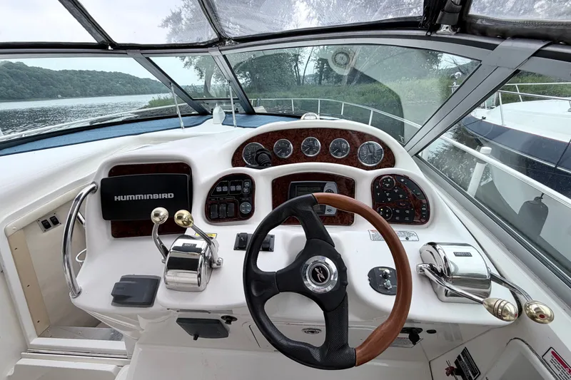 Slide: The Image of Cockpit view of 2006 Sea Ray Sundancer 320 with steering wheel and control panel. - 11