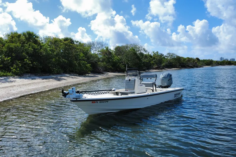 Slide: The Image of 2015 Pathfinder 2200 Tournament Edition boat on calm water near a sandy shoreline. - 17
