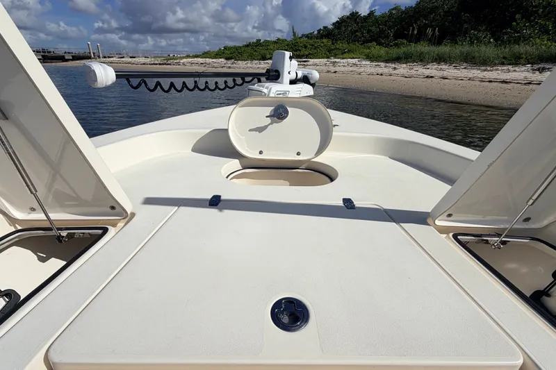 Slide: The Image of 2015 Pathfinder 2200 Tournament Edition boat deck with storage compartments, near sandy shore. - 38