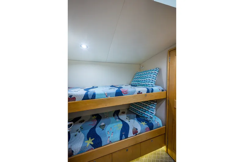 Slide: The Image of Bunk beds with nautical-themed bedding in a 1998 Buddy Davis 58 Sportfisherman cabin. - 23