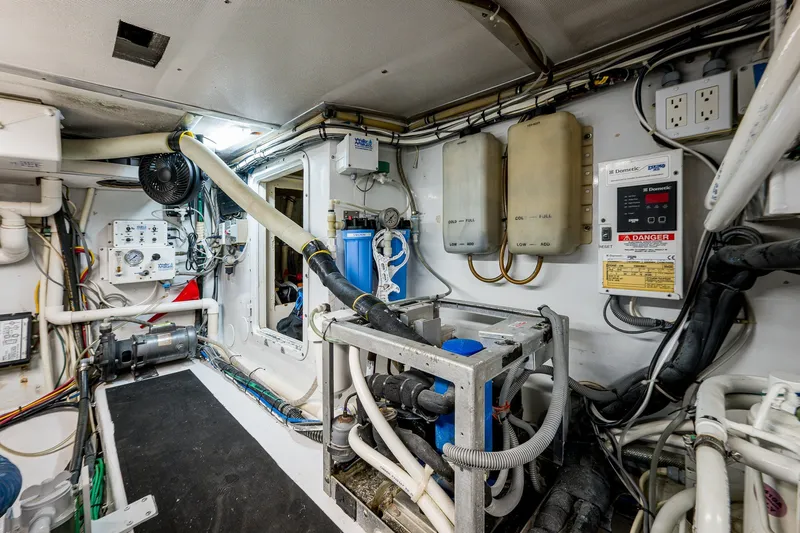 Slide: The Image of Engine room of a 1998 Buddy Davis 58 Sportfisherman, showcasing complex machinery and wiring. - 34