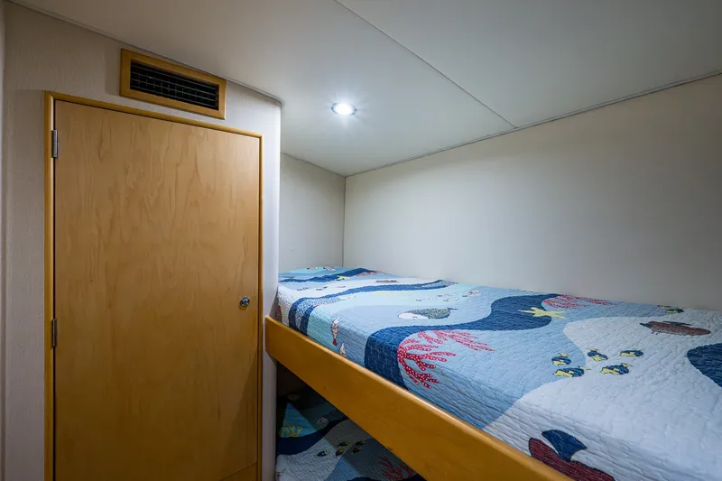 Slide: The Image of Cozy bunk bed with nautical-themed quilt in 1998 Buddy Davis 58 Sportfisherman cabin. - 22