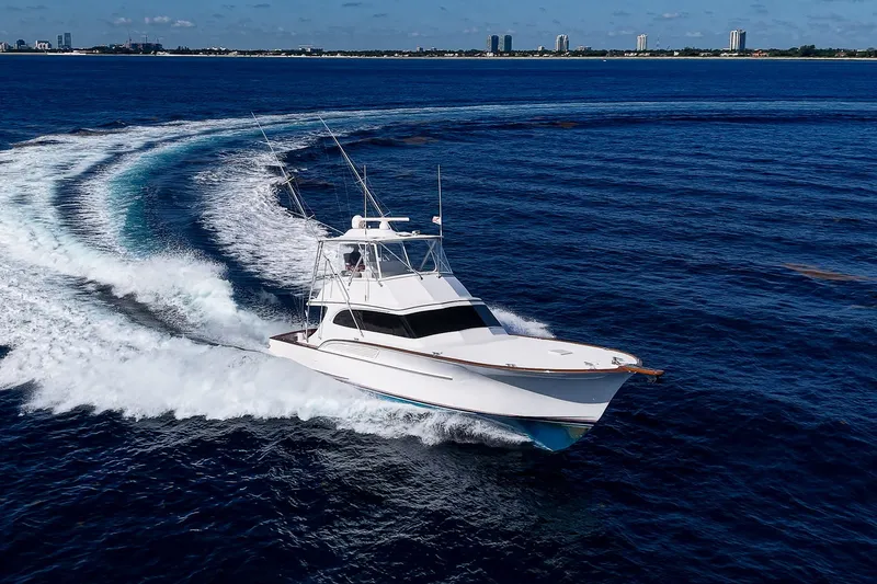 Slide: The Image of 1998 Buddy Davis 58 Sportfisherman cruising on open ocean with city skyline in background. - 39