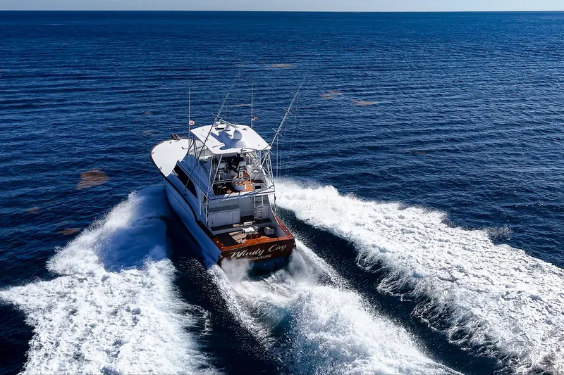 Slide: The Image of 1998 Buddy Davis 58 Sportfisherman cruising on open ocean, creating white wake trails. - 37