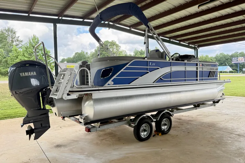Slide: The Image of 2024 Bennington L22 pontoon boat with Yamaha engine on trailer under shelter. - 4