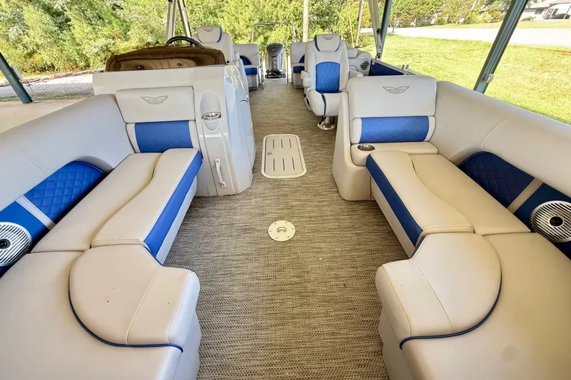 Slide: The Image of 2024 Bennington L22 pontoon boat interior with blue and beige seating, spacious layout. - 23