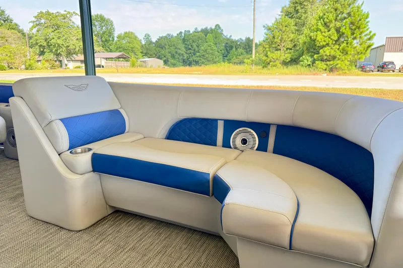 Slide: The Image of 2024 Bennington L22 boat interior with blue and white seating, cup holder, and speaker. - 20