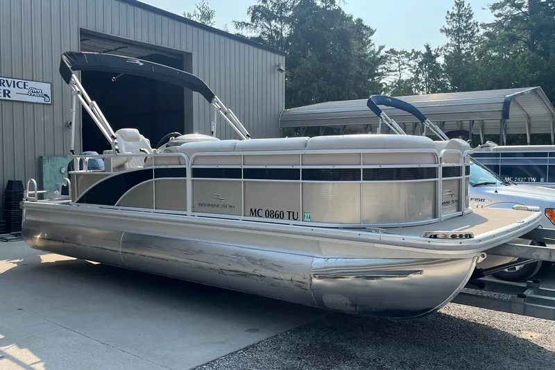 Slide: The Image of 2015 Bennington 22 SLX pontoon boat parked near a service center. - 2
