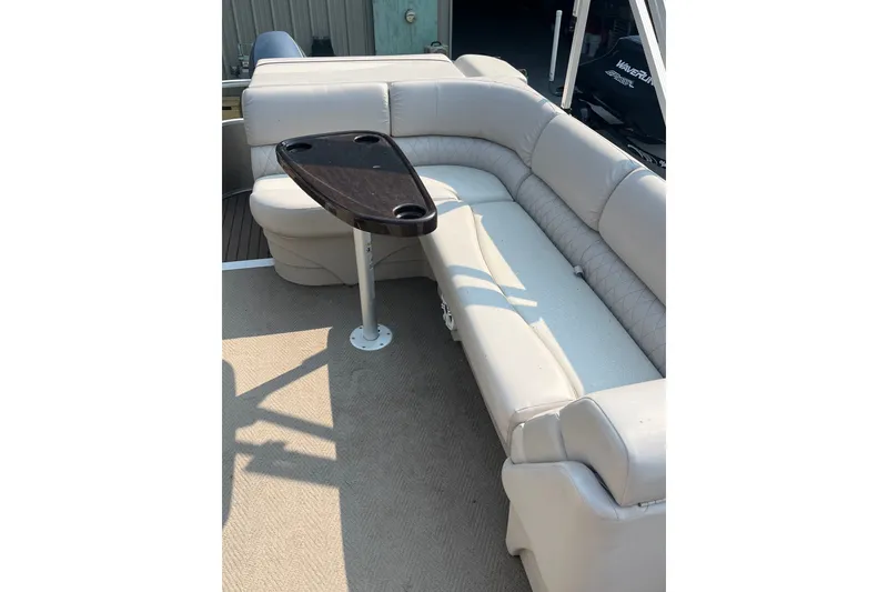 Slide: The Image of 2015 Bennington 22 SLX pontoon boat interior with beige seating and a small table. - 3