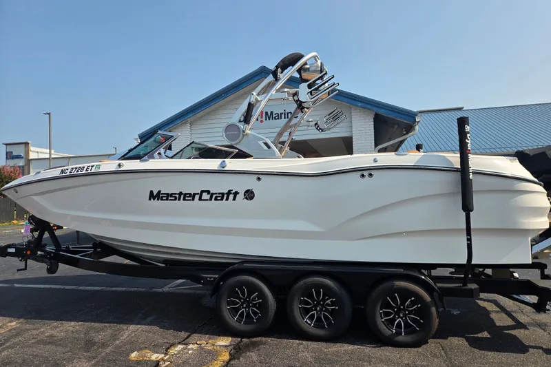 Slide: The Image of 2021 MasterCraft X24 boat on trailer outside a marine dealership. - 1