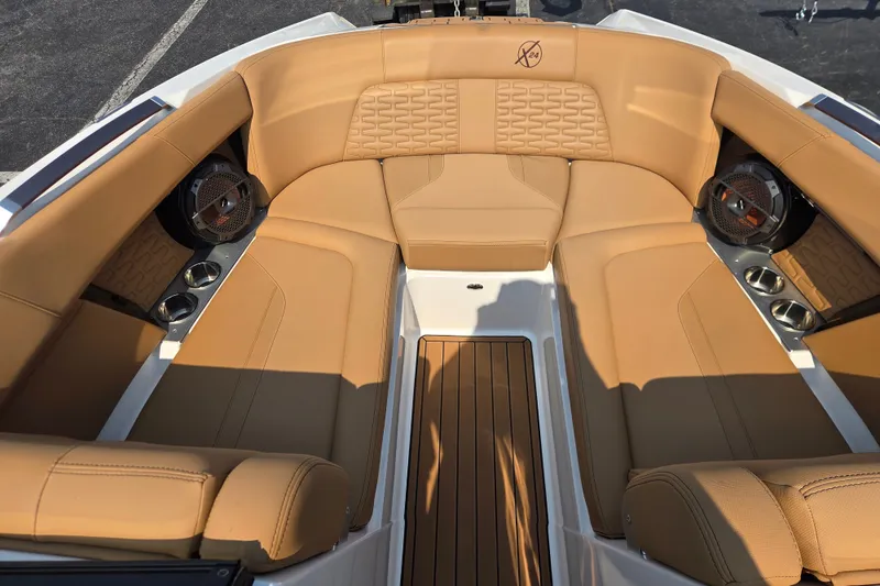 Slide: The Image of Luxurious tan seating in 2021 MasterCraft X24 boat, featuring premium speakers and cup holders. - 5