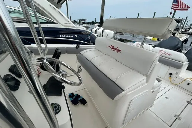 Slide: The Image of 2008 Jefferson Marlago 35 boat interior with steering wheel and seating at a marina. - 5