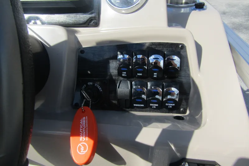 Slide: The Image of Control panel of 2026 Tahoe Pontoon Sport 85 Rear Fish 21 with switches and key. - 19