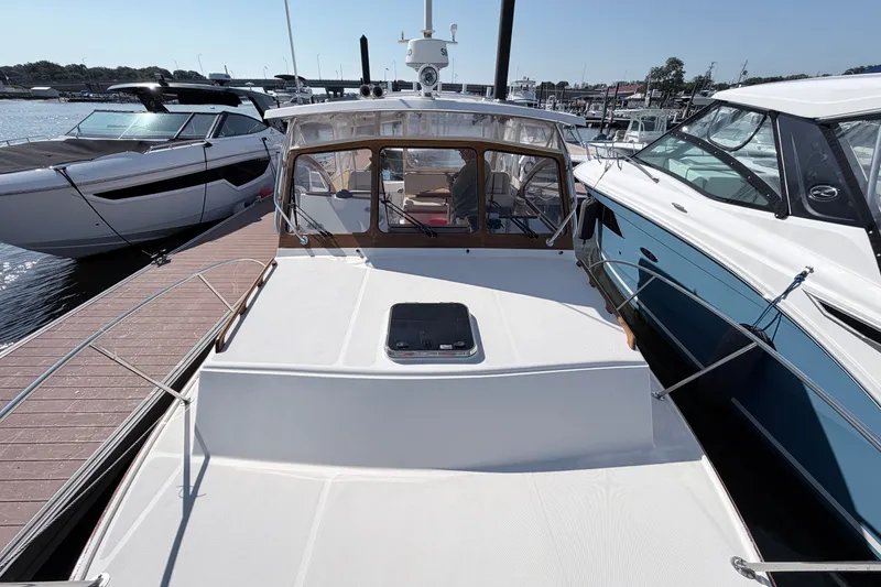 Slide: The Image of 2015 Fortier 30 boat docked at marina, surrounded by other vessels. - 15