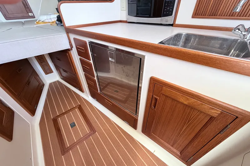 Slide: The Image of Modern galley kitchen in 2015 Fortier 30 boat with wood cabinetry and stainless steel sink. - 21