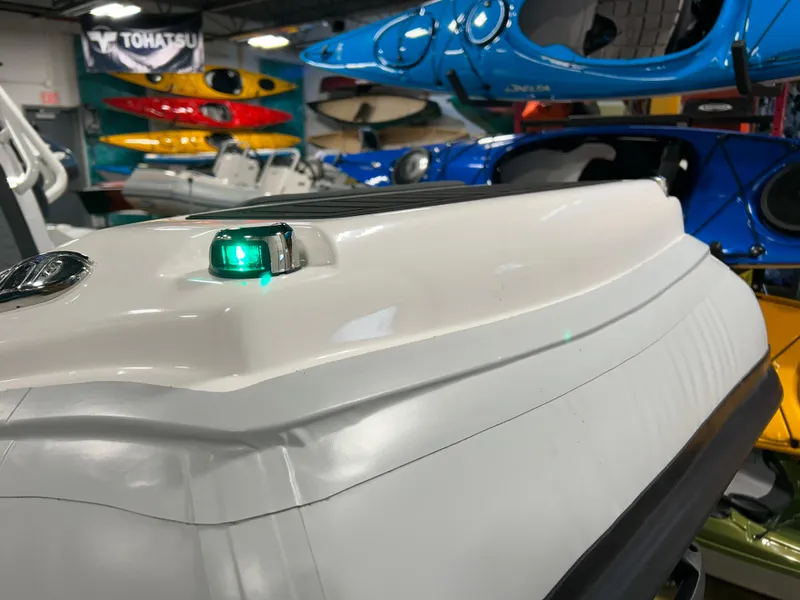 Slide: The Image of 2025 Highfield Sport 420 boat detail in showroom with colorful kayaks in background. - 6