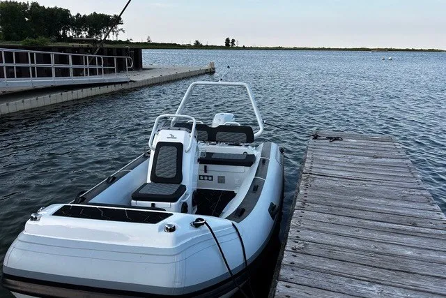 Slide: The Image of 2026 Highfield Sport 420 boat docked on a serene lake with clear skies. - 2