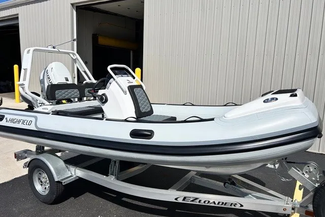 Slide: The Image of 2026 Highfield Sport 420 boat on EZ Loader trailer, parked outside a building. - 0