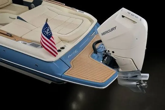 Slide: The Image of 2026 Chris-Craft Sportster 28 boat with Mercury engine and American flag on deck. - 2