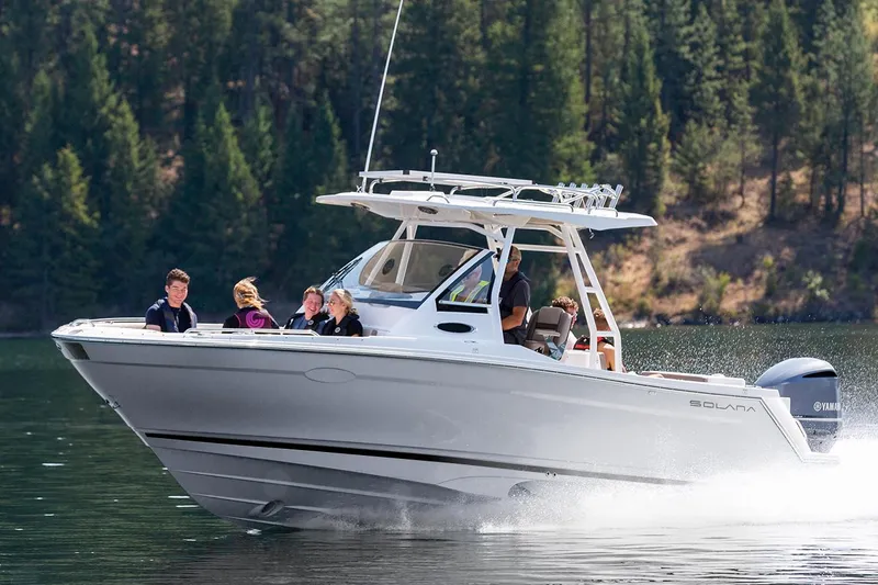 Slide: The Image of Manufacturer Provided Image: 2025 Solara S-250 CW boat cruising on a lake with passengers, surrounded by forest. - 3