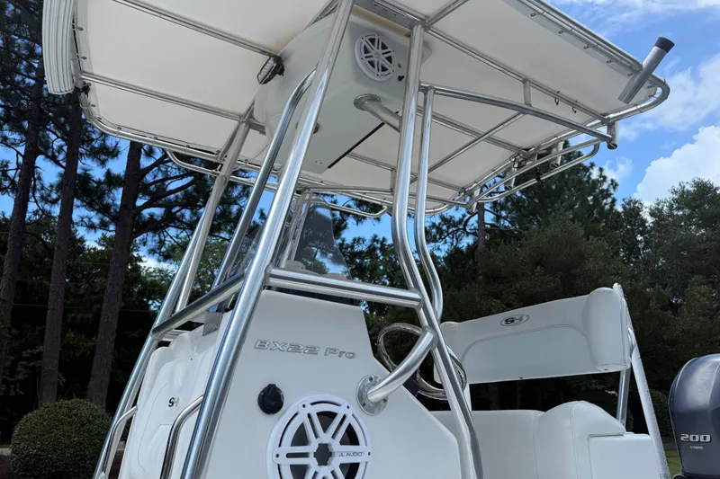 Slide: The Image of 2015 Sea Hunt BX22 Pro boat with T-top and speaker, set against a forested backdrop. - 24