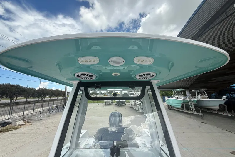 Slide: The Image of 2024 Sportsman Heritage 231 Center Console boat with teal T-top and speakers. - 16