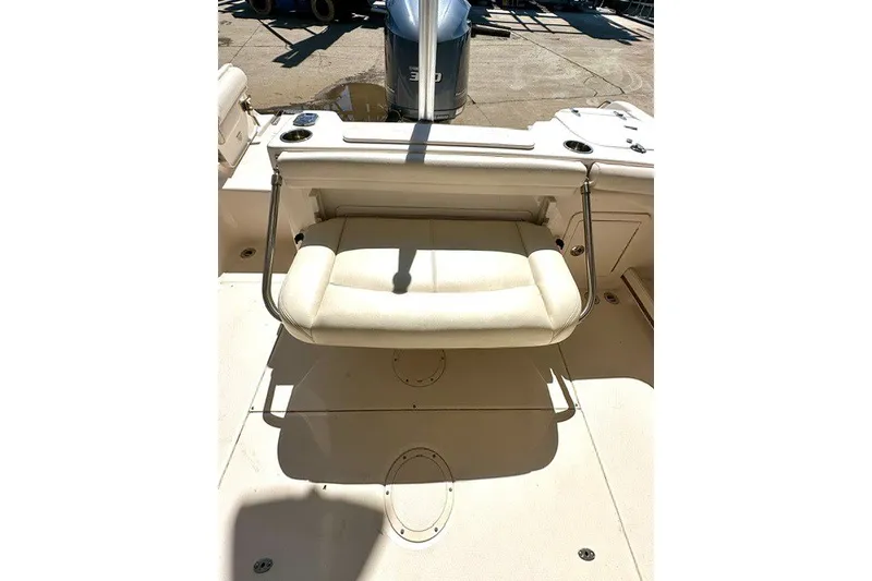 Slide: The Image of 2015 Grady-White Freedom 255 boat interior with cushioned seating and outboard motor. - 10