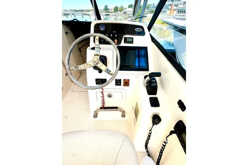 Slide: The Image of 2015 Grady-White Freedom 255 boat helm with steering wheel and control panel. - 6