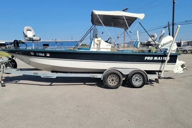 Slide: The Image of 1999 ProMaster 220 Bay boat on trailer, featuring Johnson outboard motor and canopy. - 3