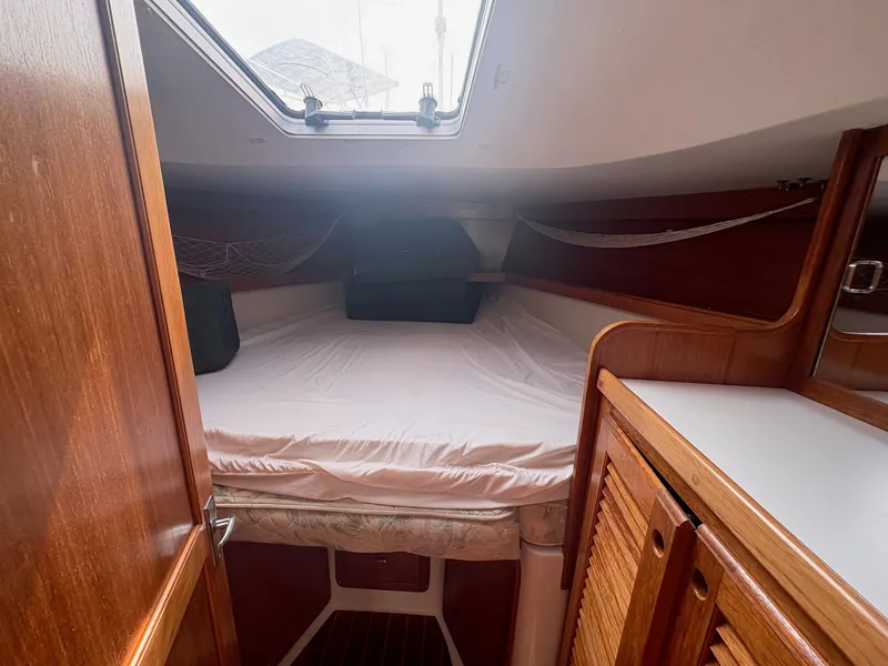 Slide: The Image of Cabin of a 1997 Catalina 36 with a large bed and wood paneling. - 29