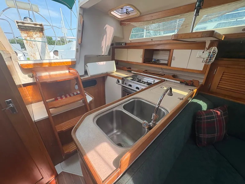 Slide: The Image of Interior view of a 1997 Catalina 36 featuring a kitchen and seating area. - 20
