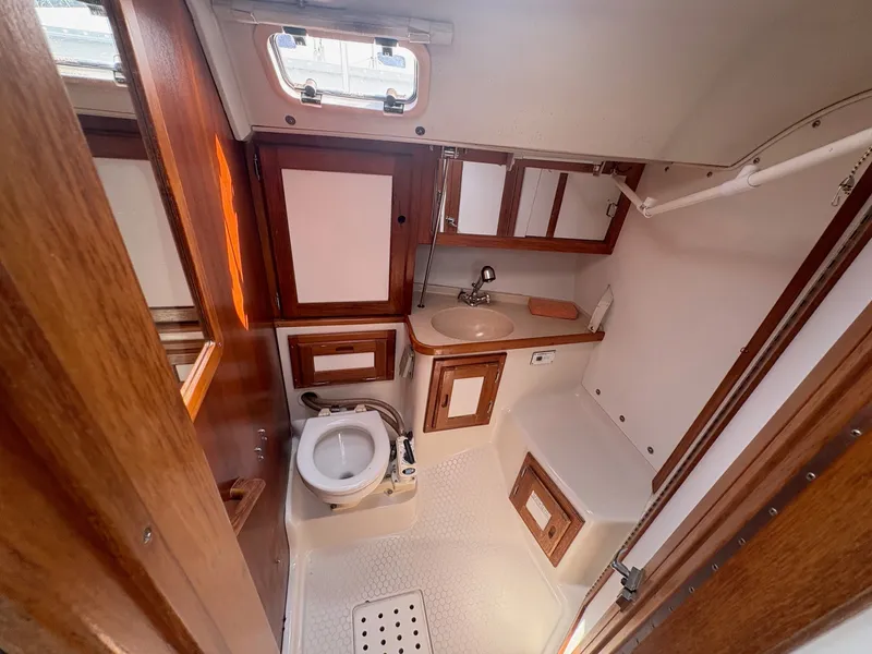 Slide: The Image of Interior view of a 1997 Catalina 36 bathroom with wooden cabinets and a sink. - 27