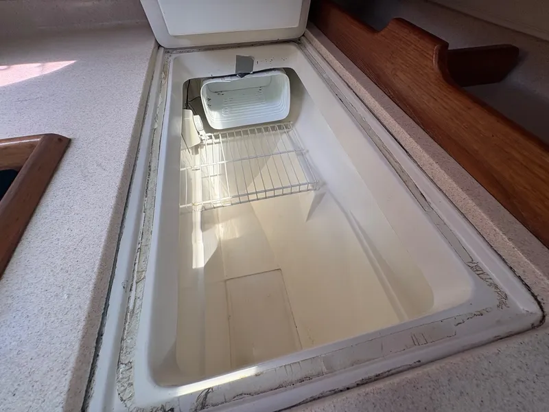 Slide: The Image of An open refrigerator in a boat's galley with wood paneling. - 23