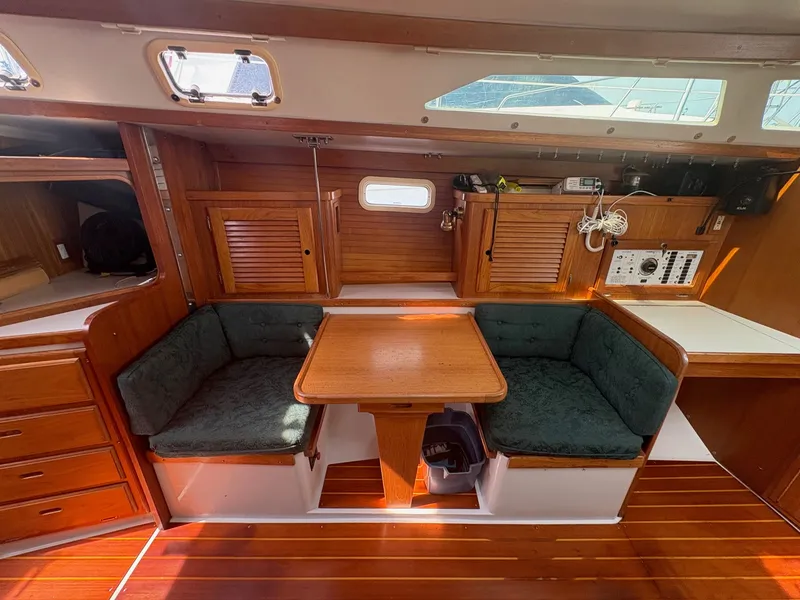 Slide: The Image of Interior of a 1997 Catalina 36 with wooden furnishings and green cushions. - 19