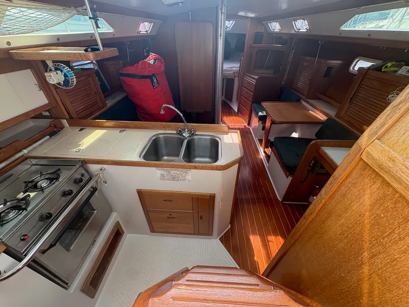 Slide: The Image of Interior of a 1997 Catalina 36 featuring a kitchen, sink, stove, and dining area. - 15