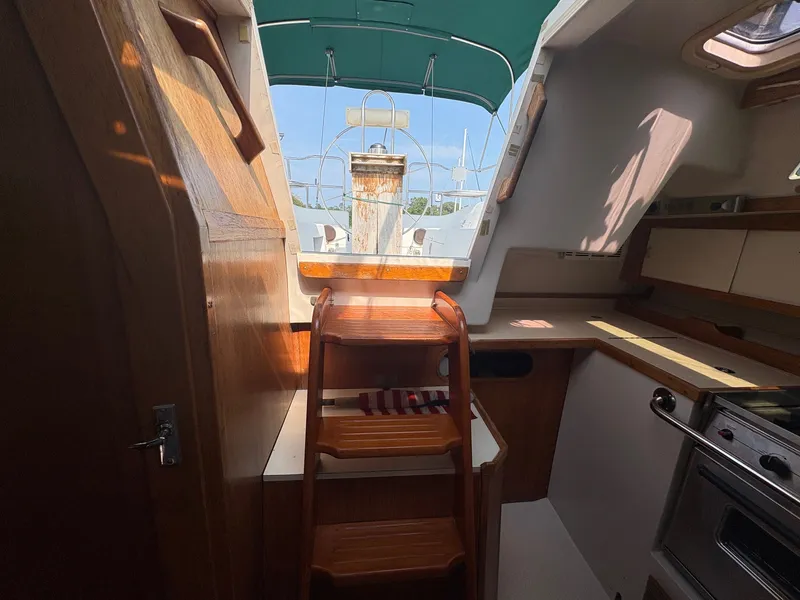Slide: The Image of Interior view of a 1997 Catalina 36 with wooden steps and a galley. - 32