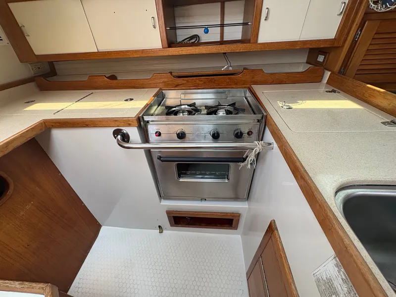 Slide: The Image of Interior view of a 1997 Catalina 36 featuring a galley with a stove and cabinets. - 24