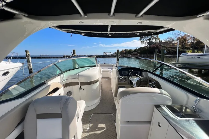 Slide: The Image of Interior view of a 2013 Sea Ray 300 SLX boat docked by the water. - 4