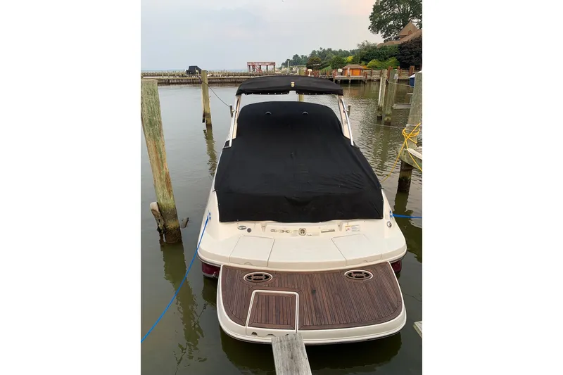 Slide: The Image of 2013 Sea Ray 300 SLX boat docked with black cover, rear view. - 7