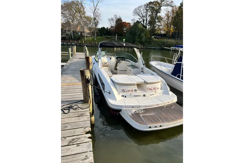 Slide: The Image of 2013 Sea Ray 300 SLX boat docked at a wooden pier on a calm lake. - 1