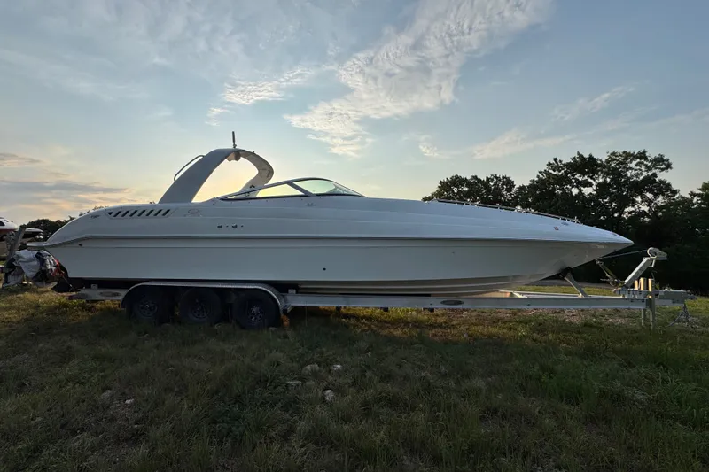 Slide: The Image of 2008 Envision 3600 Legacy ESP boat on trailer, parked on grassy field at sunset. - 3