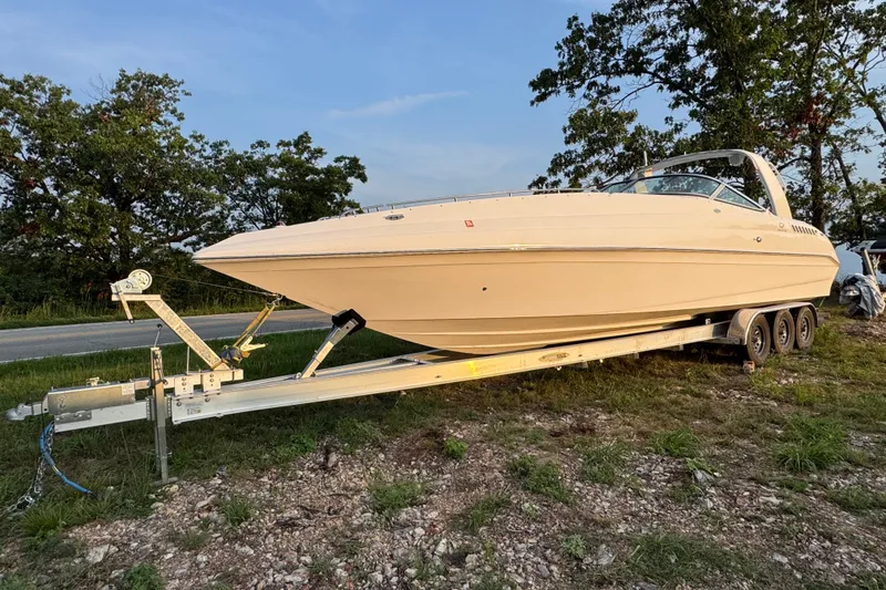 Slide: The Image of 2008 Envision 3600 Legacy ESP boat on trailer, parked outdoors near trees. - 2