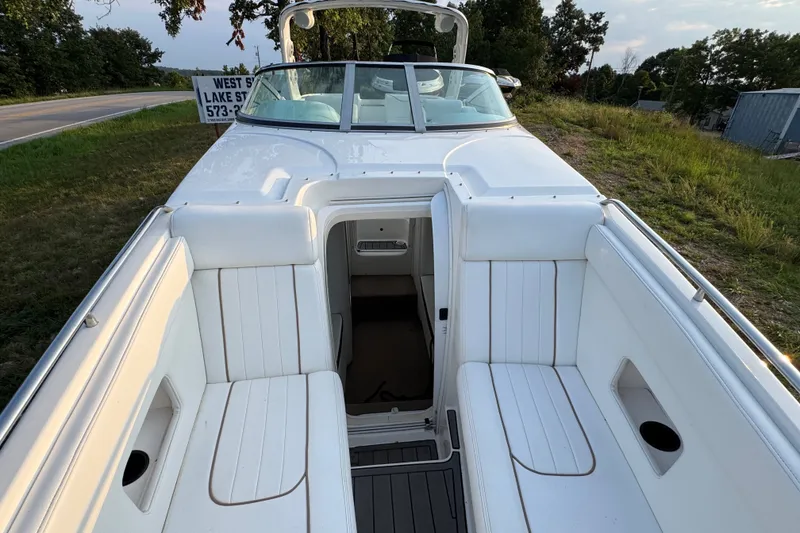 Slide: The Image of 2008 Envision 3600 Legacy ESP boat with white seating and open cockpit, parked near a road. - 25